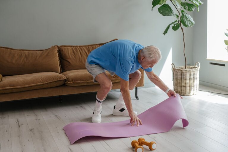 Người cao tuổi đang trải thảm yoga trong nhà