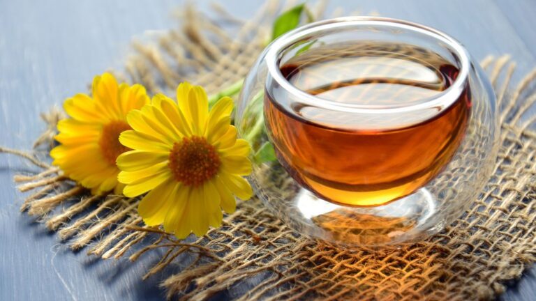 Tách trà thảo mộc bốc khói thơm trên bàn gỗ