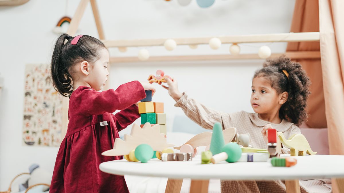Nhóm trẻ em chạy nhảy vui chơi ngoài trời trong nắng sớm